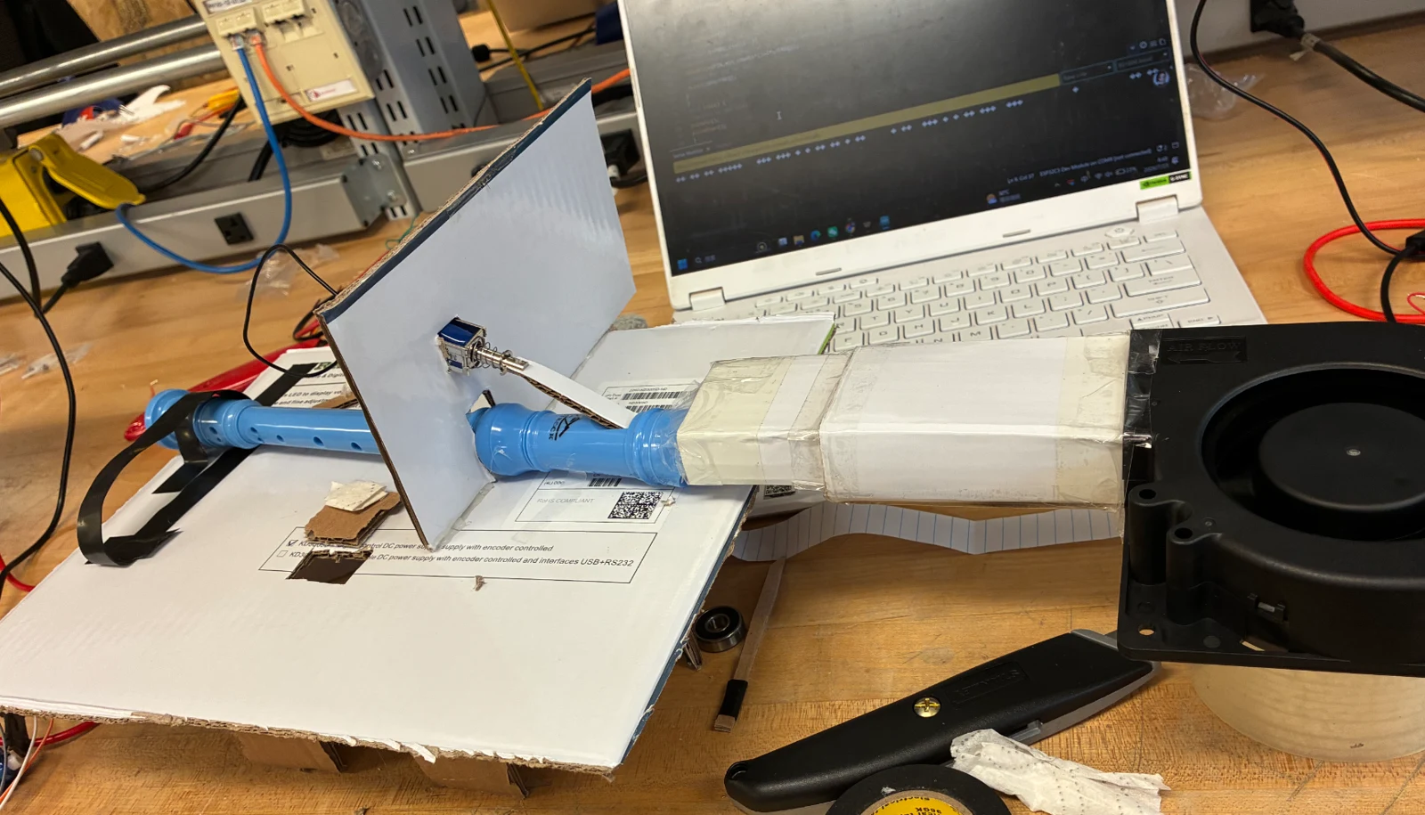 A blower connected to a prototype airflow tunnel and recorder.
